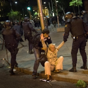 Mulher é socorrida durante confronto entre policiais e manifestantes em Madri, na Espanha