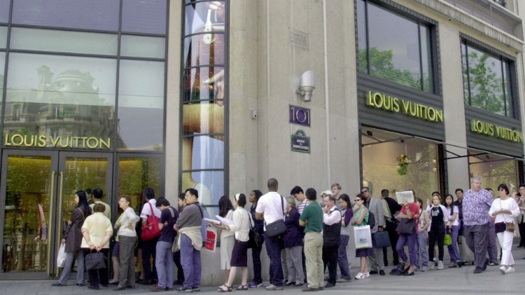 Turistas em fila para entrar na megastore Louis Vuitton, na Champs-Elysées, em Paris